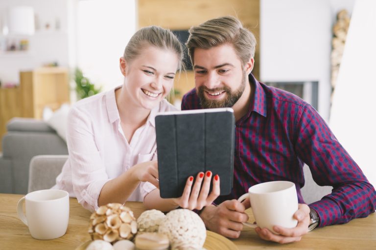 cheerful couple with tablet desk